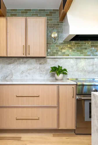 Custom Vero Beach kitchen with light wood cabinetry, green tile backsplash, and marble-look countertops